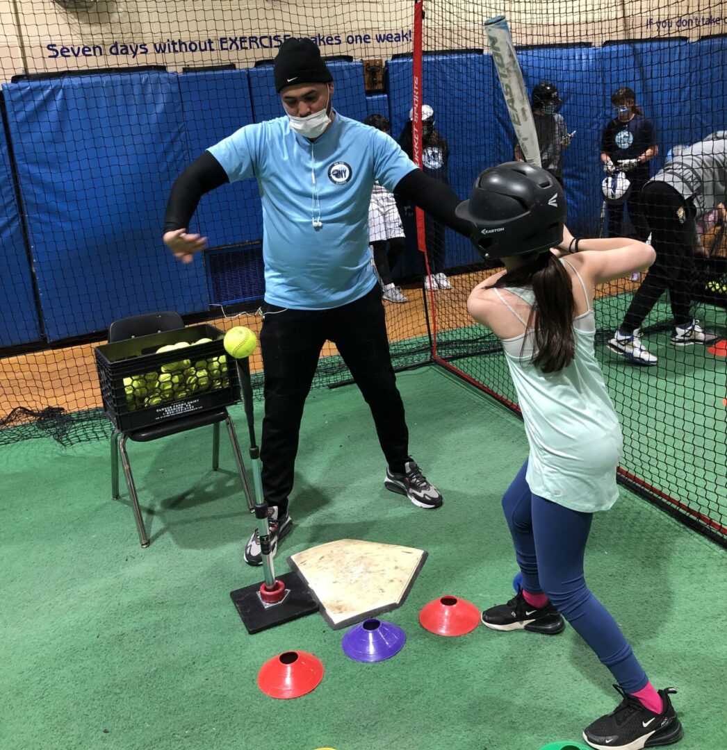 Softball Hitting with a trainer teaching a kid